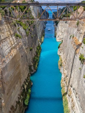 Yunanistan 'ın Mora kentindeki güneşli bir günde Corinth Kanalı' ndan geçen tekne ve yatların köprüden görünüşü