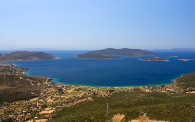 Yunanistan 'ın Evia adasındaki Marmari kasabası yakınlarındaki Ege Denizi ve Yunan köyünün panoramik manzarası güneşli bir günde
