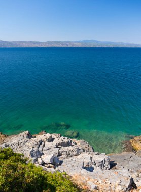 Yunanistan 'ın Evia adasındaki Ege Denizi' nin kayalıklarından tepedeki manzara güneşli bir günde