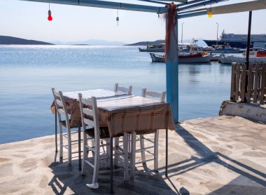 Yunanistan 'ın Evia adasındaki tatil beldesi Marmari' nin rıhtımındaki Coronavirus salgınının ortasında müşterisiz bir taverna.