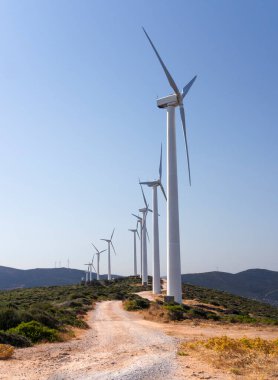 Yunanistan 'ın Evia adasında mavi gökyüzüne karşı beyaz rüzgar türbinleri