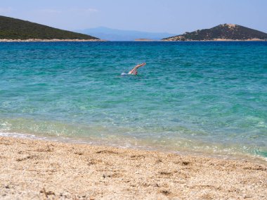 Marmari, Evia Adası, Yunanistan. Ağustos 2020: Yunanistan 'ın Evia adasında Ege Denizi' nde bir adam yüzüyor