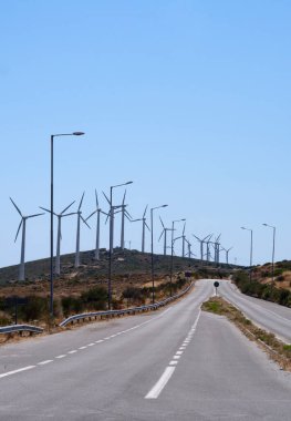 Yunanistan 'ın Evia adasında ufukta rüzgar türbinleri beliren asfalt otoyol