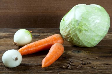 Ahşap bir masada lahana havuç ve soğan