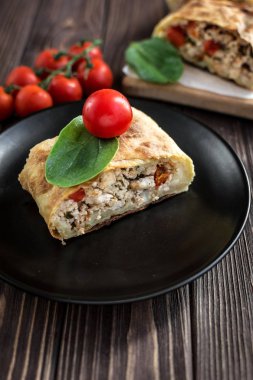 Ahşap arka plan üzerinde etli lezzetli ev yapımı strudel