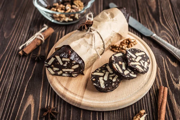 Ahşap arka plan üzerinde çikolata sosis. Tatlı yaptı bisküvi, çikolata ve fındık bir ahşap tahta üzerine dilimlenmiş