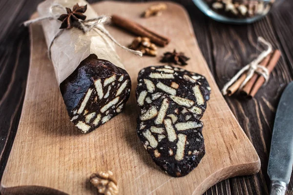 Ahşap arka plan üzerinde çikolata sosis. Tatlı yaptı bisküvi, çikolata ve fındık bir ahşap tahta üzerine dilimlenmiş