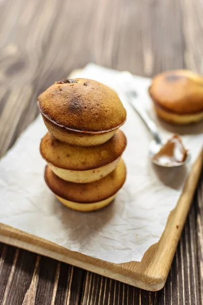 Köstliche Hausgemachte Cupcakes Mit Brauner Sahne Und Milch Auf Holzgrund — Stockfoto