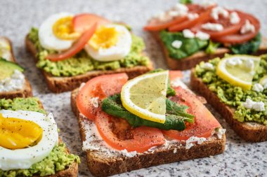 Ev yapımı sağlıklı avokado ve yumurta tost. Tost, avokado, yumurta, domates, ıspanak, beyaz peynir, limon. Organik sağlıklı gıda. Sağlıklı beslenme temiz