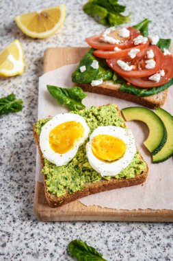 Ev yapımı sağlıklı avokado ve yumurta tost. Tost, avokado, yumurta, domates, ıspanak, beyaz peynir, limon. Organik sağlıklı gıda. Sağlıklı beslenme temiz