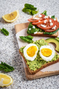 Ev yapımı sağlıklı avokado ve yumurta tost. Tost, avokado, yumurta, domates, ıspanak, beyaz peynir, limon. Organik sağlıklı gıda. Sağlıklı beslenme temiz