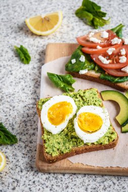 Ev yapımı sağlıklı avokado ve yumurta tost. Tost, avokado, yumurta, domates, ıspanak, beyaz peynir, limon. Organik sağlıklı gıda. Sağlıklı beslenme temiz