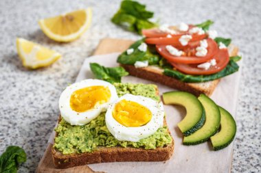 Ev yapımı sağlıklı avokado ve yumurta tost. Tost, avokado, yumurta, domates, ıspanak, beyaz peynir, limon. Organik sağlıklı gıda. Sağlıklı beslenme temiz