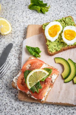 Ev yapımı sağlıklı avokado ve yumurta tost. Tost, avokado, yumurta, domates, ıspanak, beyaz peynir, limon. Organik sağlıklı gıda. Sağlıklı beslenme temiz