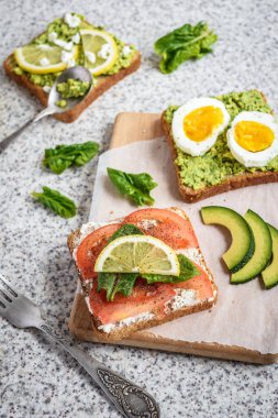Ev yapımı sağlıklı avokado ve yumurta tost. Tost, avokado, yumurta, domates, ıspanak, beyaz peynir, limon. Organik sağlıklı gıda. Sağlıklı beslenme temiz