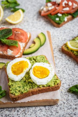 Ev yapımı sağlıklı avokado ve yumurta tost. Tost, avokado, yumurta, domates, ıspanak, beyaz peynir, limon. Organik sağlıklı gıda. Sağlıklı beslenme temiz