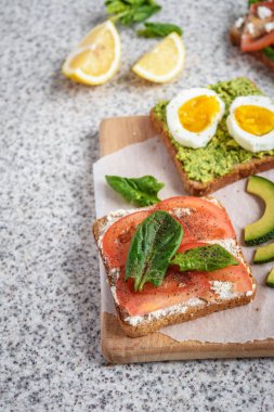 Ev yapımı sağlıklı avokado ve yumurta tost. Tost, avokado, yumurta, domates, ıspanak, beyaz peynir, limon. Organik sağlıklı gıda. Sağlıklı beslenme temiz