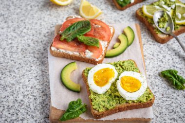 Ev yapımı sağlıklı avokado ve yumurta tost. Tost, avokado, yumurta, domates, ıspanak, beyaz peynir, limon. Organik sağlıklı gıda. Sağlıklı beslenme temiz