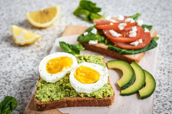 Homemade healthy avocado and egg toasts. Toast, avocado, egg, tomatoes, spinach, cheese Feta, lemon. Organic healthy food. Clean healthy eating