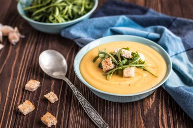 Ahşap bir arka planda kruton ve yeşillikler ile lezzetli bezelye çorbası. Bezelye krem çorbası.