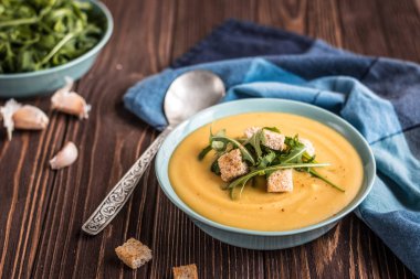 Ahşap bir arka planda kruton ve yeşillikler ile lezzetli bezelye çorbası. Bezelye krem çorbası.