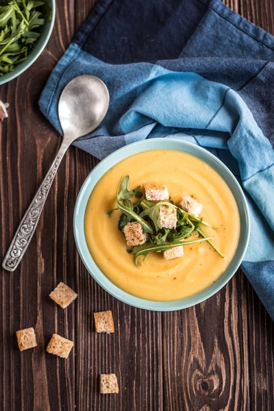 Ahşap bir arka planda kruton ve yeşillikler ile lezzetli bezelye çorbası. Bezelye krem çorbası.