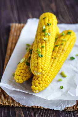 Pişirme tereyağı ve yeşillik eritme altında Izgara tatlı mısır koçan