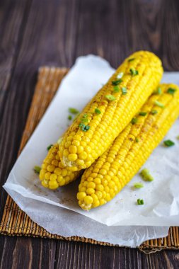 Pişirme tereyağı ve yeşillik eritme altında Izgara tatlı mısır koçan