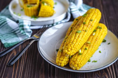 Pişirme tereyağı ve yeşillik eritme altında Izgara tatlı mısır koçan