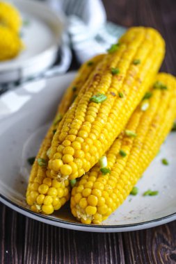 Pişirme tereyağı ve yeşillik eritme altında Izgara tatlı mısır koçan