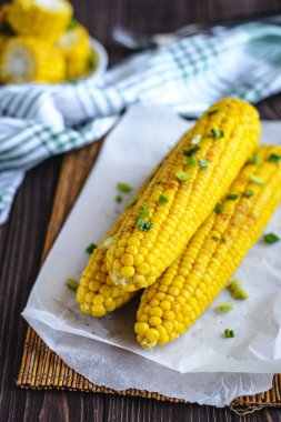 Pişirme tereyağı ve yeşillik eritme altında Izgara tatlı mısır koçan