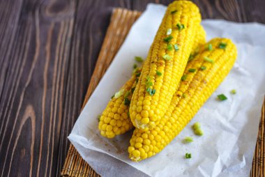 Pişirme tereyağı ve yeşillik eritme altında Izgara tatlı mısır koçan