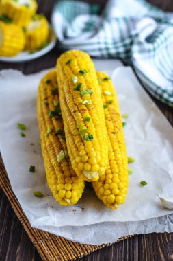 Pişirme tereyağı ve yeşillik eritme altında Izgara tatlı mısır koçan