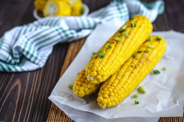 Pişirme tereyağı ve yeşillik eritme altında Izgara tatlı mısır koçan