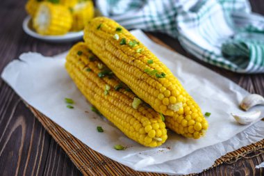 Pişirme tereyağı ve yeşillik eritme altında Izgara tatlı mısır koçan