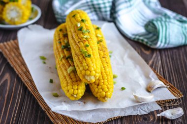 Pişirme tereyağı ve yeşillik eritme altında Izgara tatlı mısır koçan