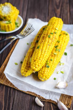 Pişirme tereyağı ve yeşillik eritme altında Izgara tatlı mısır koçan