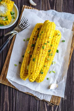 Pişirme tereyağı ve yeşillik eritme altında Izgara tatlı mısır koçan