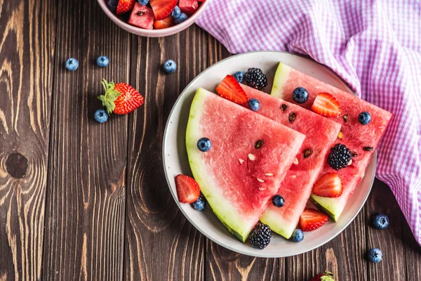Çilek, Yaban Mersini, Karpuz ve Siyah berry ahşap bir arka plan üzerinde Taze Berry karışımı. Karpuzunu kes. Sulu ve tatlı karpuz
