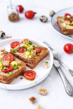 Jambon ve sahanda yumurtalı sandviç, jambon ve domatesli sahanda yumurta ve gri beton masa. Yakın çekim, üst görünüm.