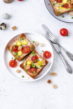 Jambon ve sahanda yumurtalı sandviç, jambon ve domatesli sahanda yumurta ve gri beton masa. Yakın çekim, üst görünüm.