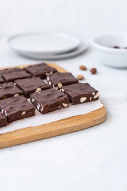 Gri arka planda fındıklı lezzetli çikolata şekerlemesi. Ev yapımı siyah çikolatalı brownie..