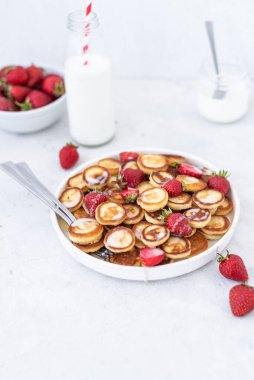 Hafif arka planda çilekli ev yapımı mini krepler. Lezzetli bir kahvaltı. Gıda trend. Bebek maması.