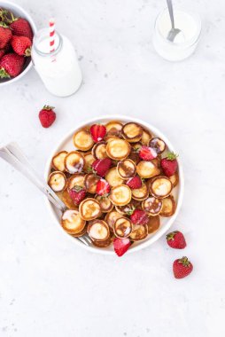 Hafif arka planda çilekli ev yapımı mini krepler. Lezzetli bir kahvaltı. Gıda trend. Bebek maması.