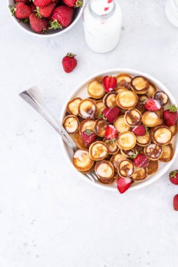 Hafif arka planda çilekli ev yapımı mini krepler. Lezzetli bir kahvaltı. Gıda trend. Bebek maması.