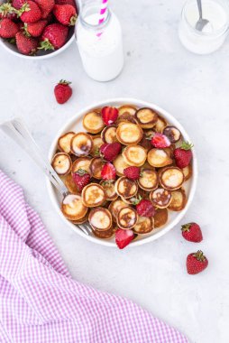 Hafif arka planda çilekli ev yapımı mini krepler. Lezzetli bir kahvaltı. Gıda trend. Bebek maması.