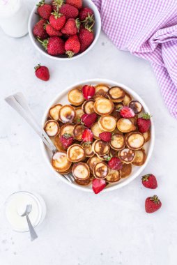 Hafif arka planda çilekli ev yapımı mini krepler. Lezzetli bir kahvaltı. Gıda trend. Bebek maması.