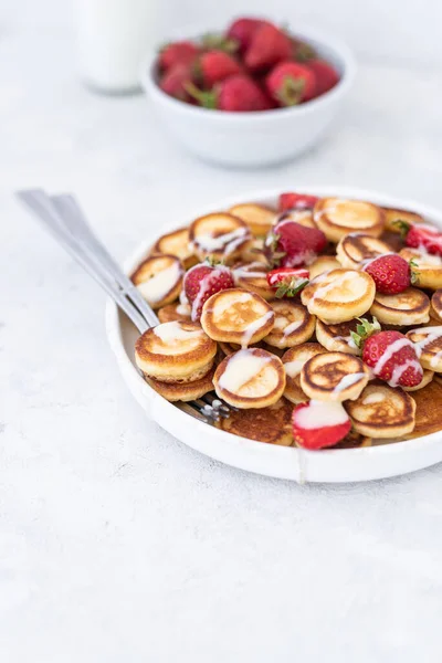 Hafif arka planda çilekli ev yapımı mini krepler. Lezzetli bir kahvaltı. Gıda trend. Bebek maması.