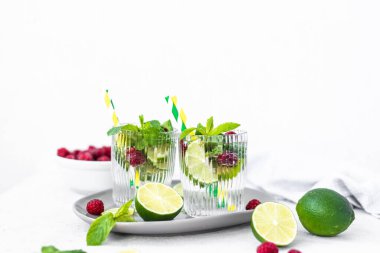 Limonlu mojito kokteyli, ahududu ve naneli bir bardak. Taze yaz kokteyli. Gri arka planda yaz mojito 'su
