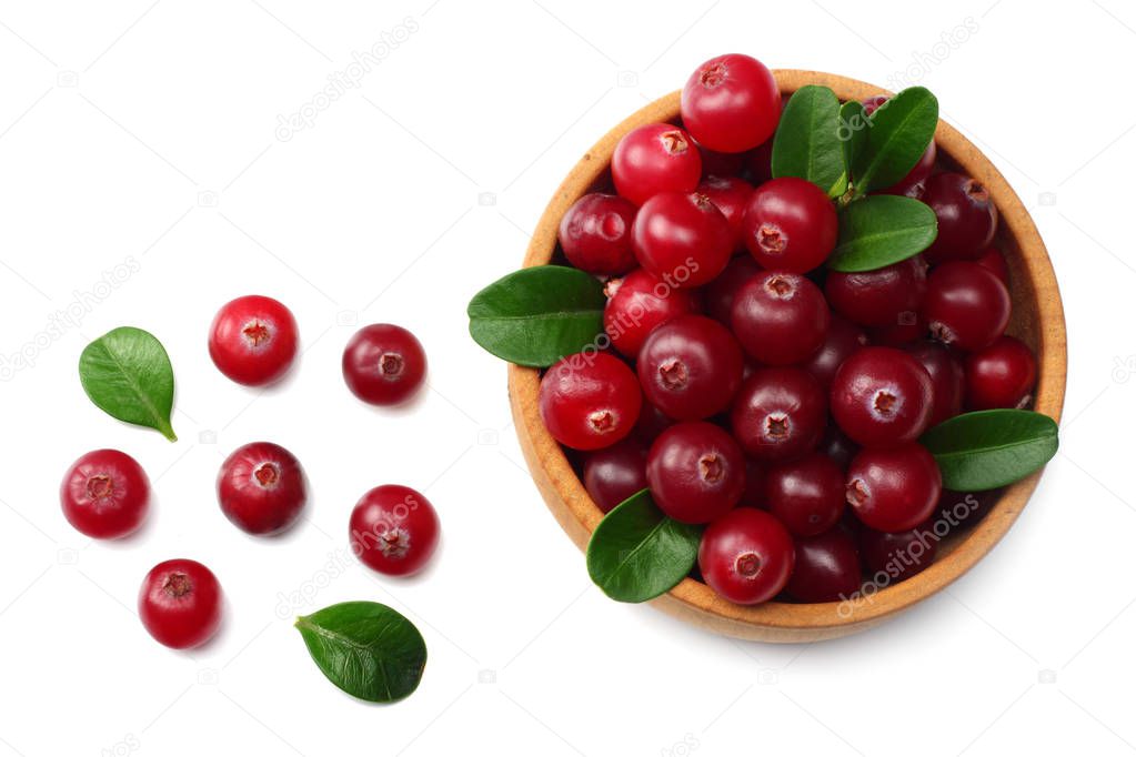 Cranberry in wooden bowl with green leaves isolated on white background. top view